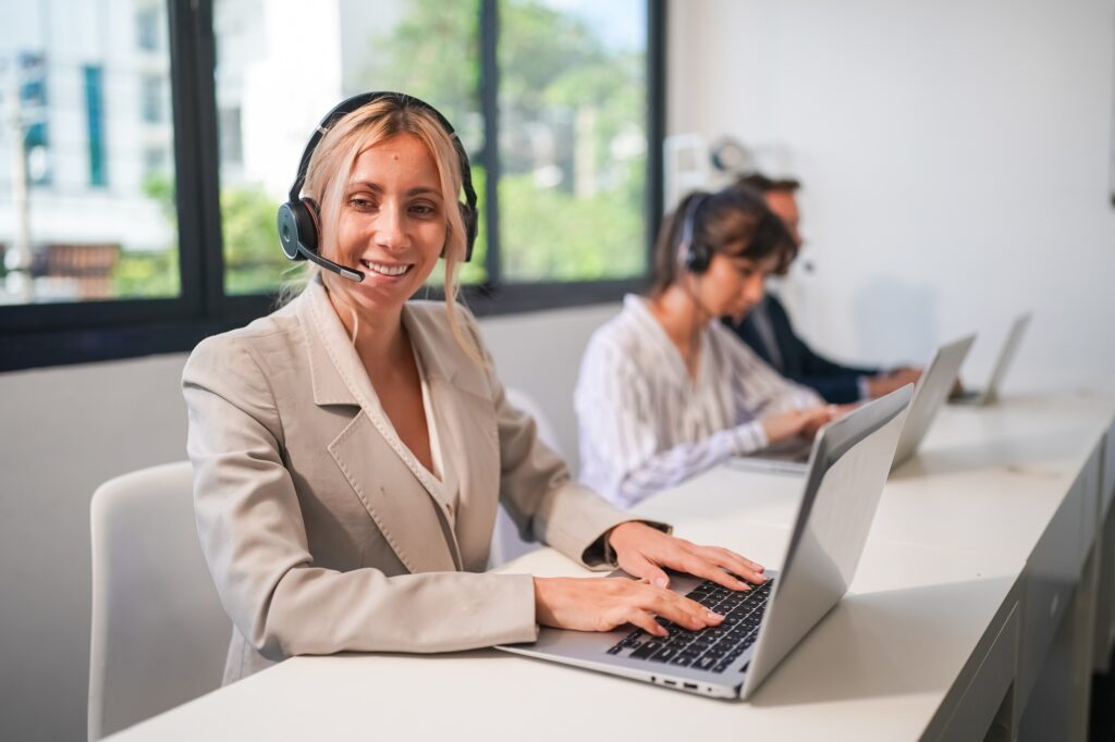 Charming business lady in headphones talking with business partner on laptop